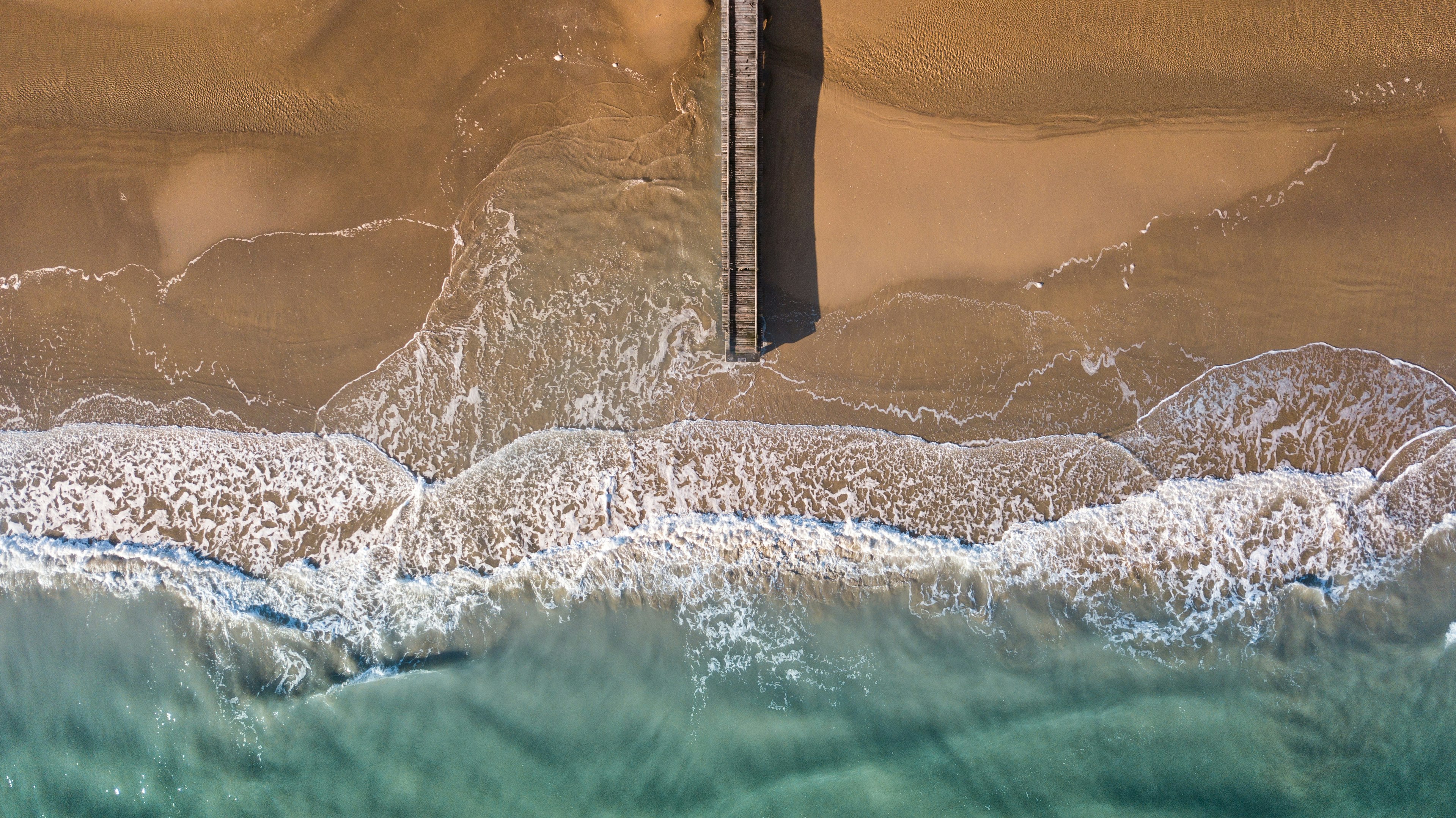 aerial photography of brown wooden dock beside sea